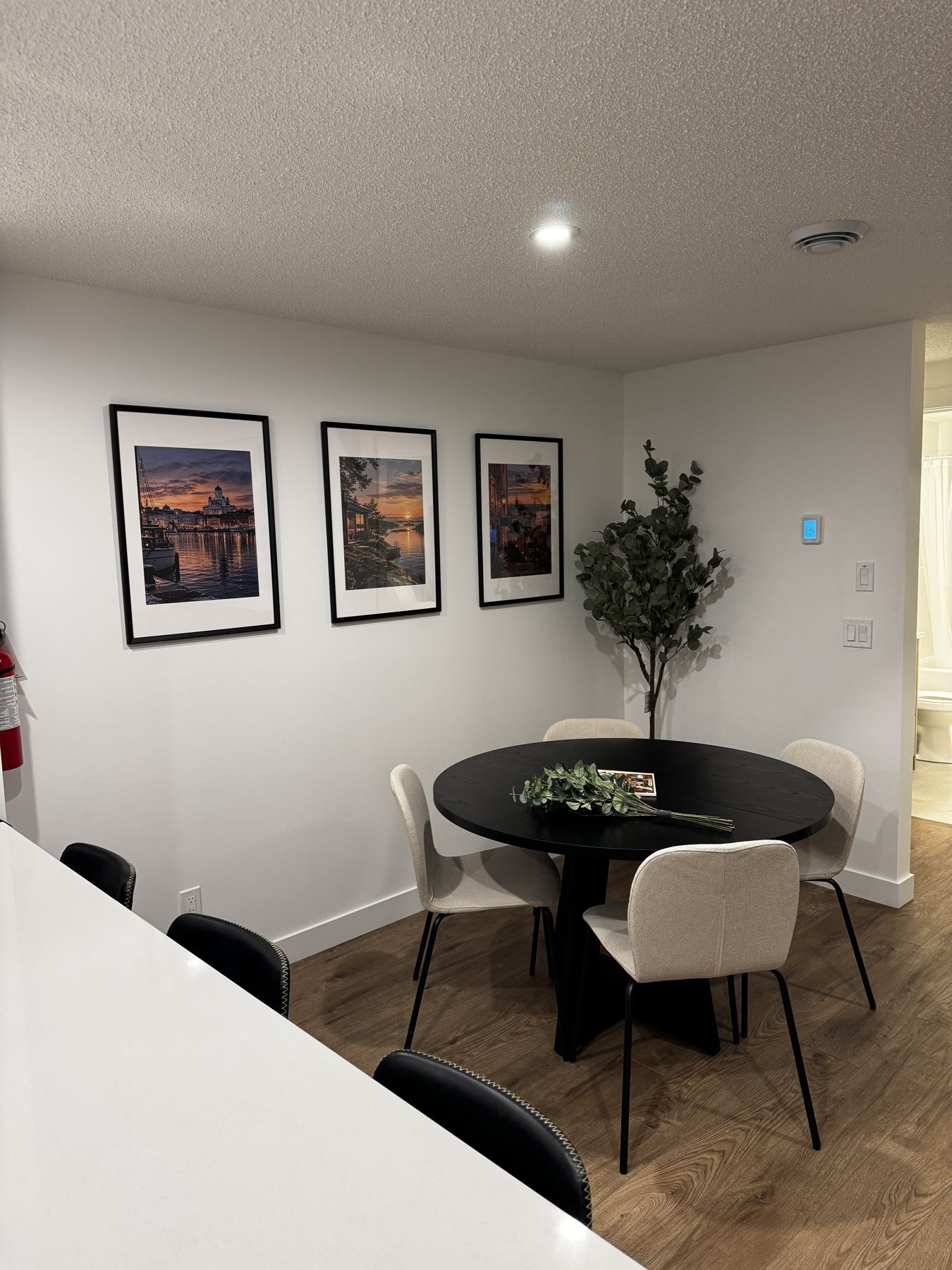 Round black dining table under three mountain prints